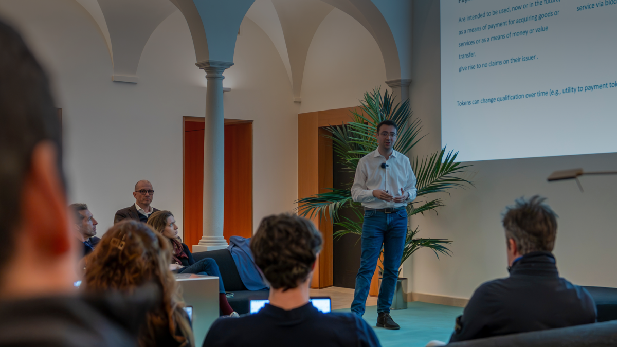 Speaker presenting to an audience at PoW.space Lugano during a seminar on regulatory differences in digital asset laws between Switzerland, the EU, and Dubai.